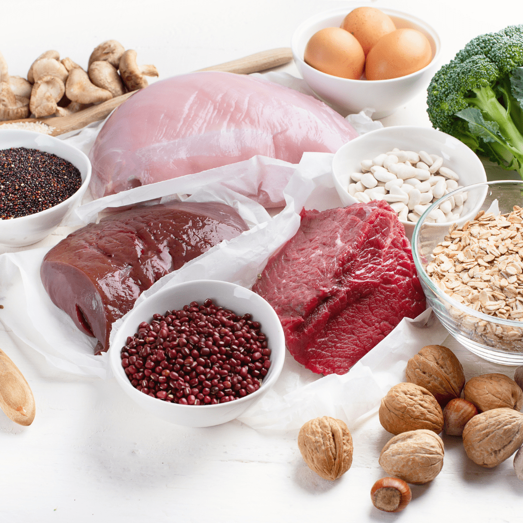 Main image for the article [Everything to know about iron and your baby]. Pictured are high iron foods including: beef, liver, chicken, broccoli, nuts, beans and oatmeal.