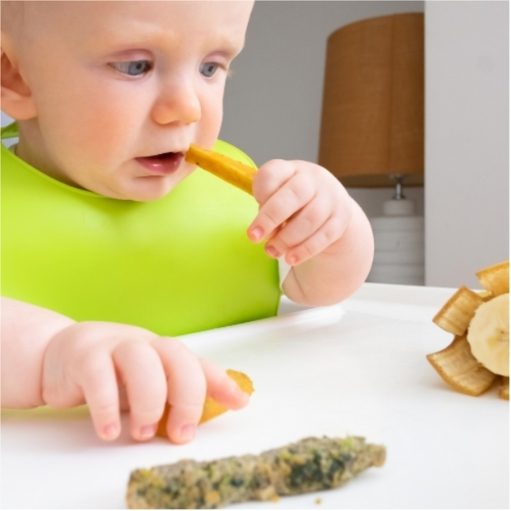 Baby trying first foods at 1 year old