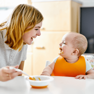Main image for the article [The Division of Responsibility in Feeding. Pictured is baby and a mother laughing and eating.