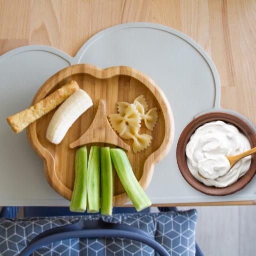 Baby eating snacks -  yogurt, fruit and slice of bread