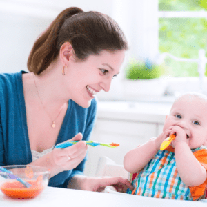 Main image for the article [Figuring out the Best Approach to Starting Solids]. Pictured is a mother feeding her baby in their highchair.