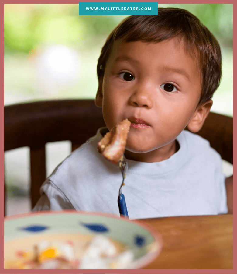 Episode art for episode: "#46: A deep dive into the best fish for your baby (and what to avoid)." Pictured is a baby sitting at the table eating a piece of fish fillet.