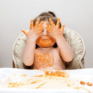 Episode art for "#44: Do You Really Need to Worry About Salt for Babies?". Pictured is a baby covering their eyes while eating pasta.
