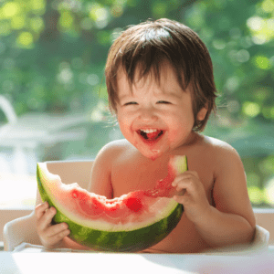 Episode art for episode "#48: Is it ever ok to limit food for your baby/toddler?". Pictured is a smiling toddler eating a large piece of watermelon.