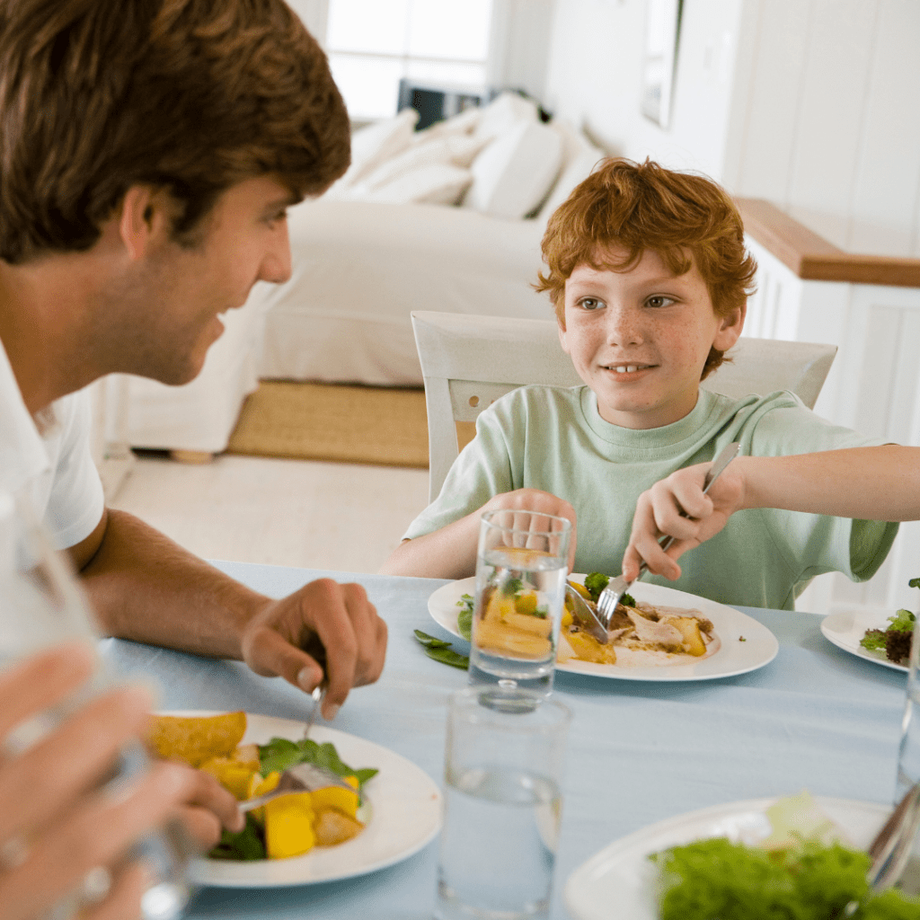 Main image for article "The importance of timing for preventing (and reversing) picky eating." Pictured is a family happily eating dinner together.