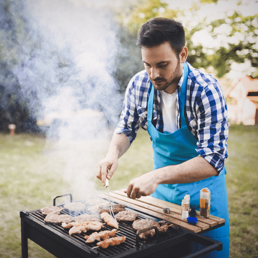 Episode art for episode: “#56: BBQ for Babies and Toddlers - Unique Food Ideas and How to Keep it Healthy and Safe”. Pictured is a man in a blue and white plaid shirt seasoning meat on a BBQ grill.