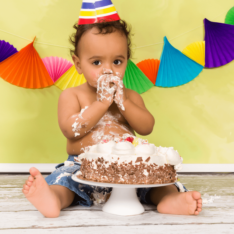 Baby enjoying their first birthday smash cake.