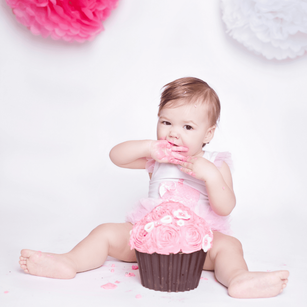 Baby eating birthday cake on first birthday