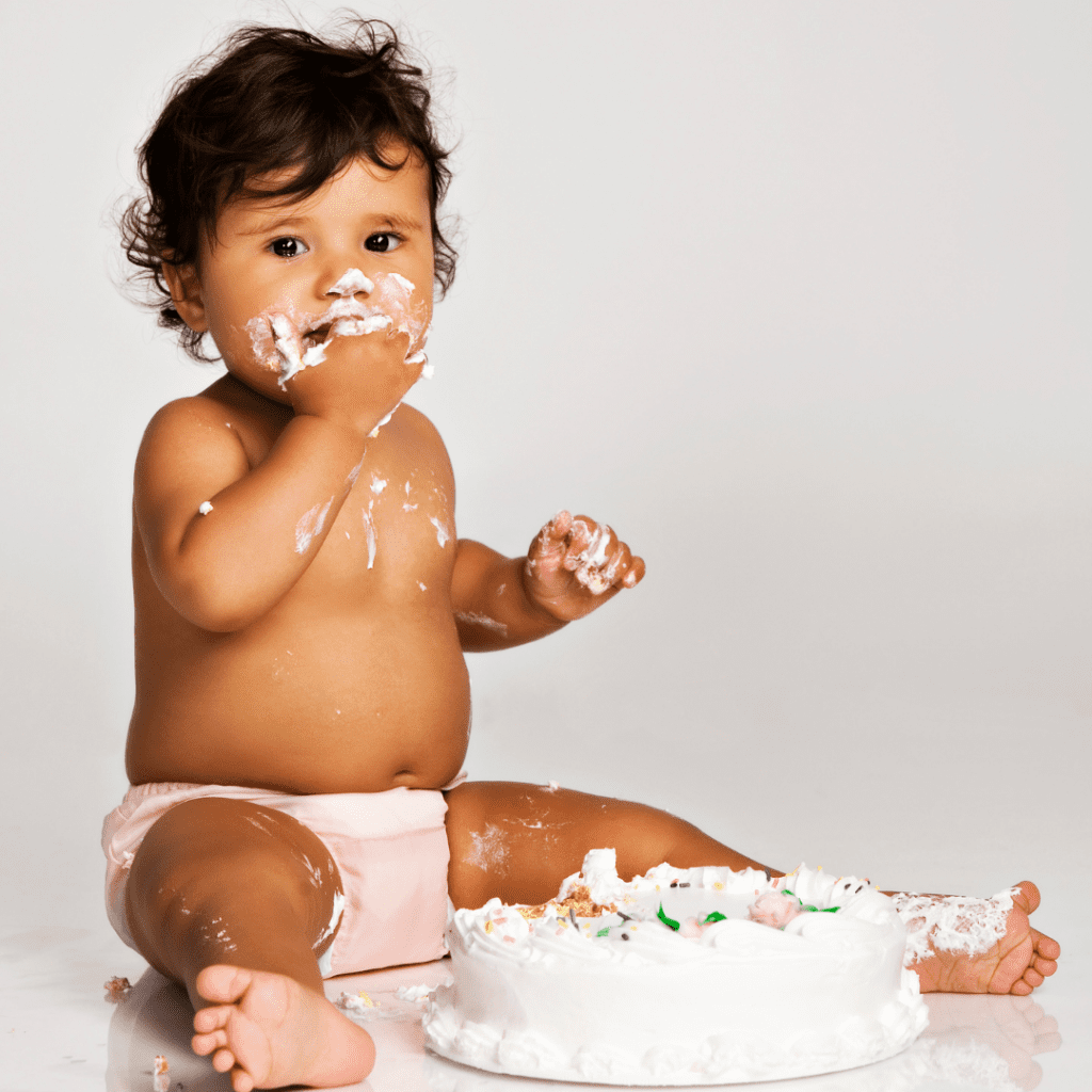 baby eating first birthday smash cake