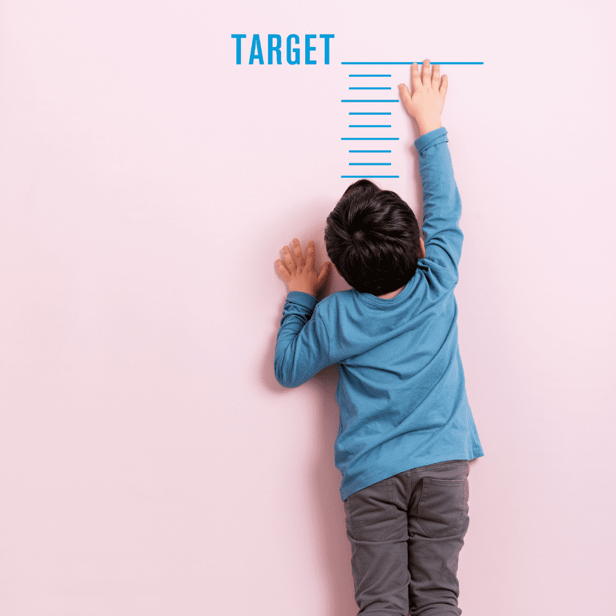 Child reaching to top of growth chart on wall
