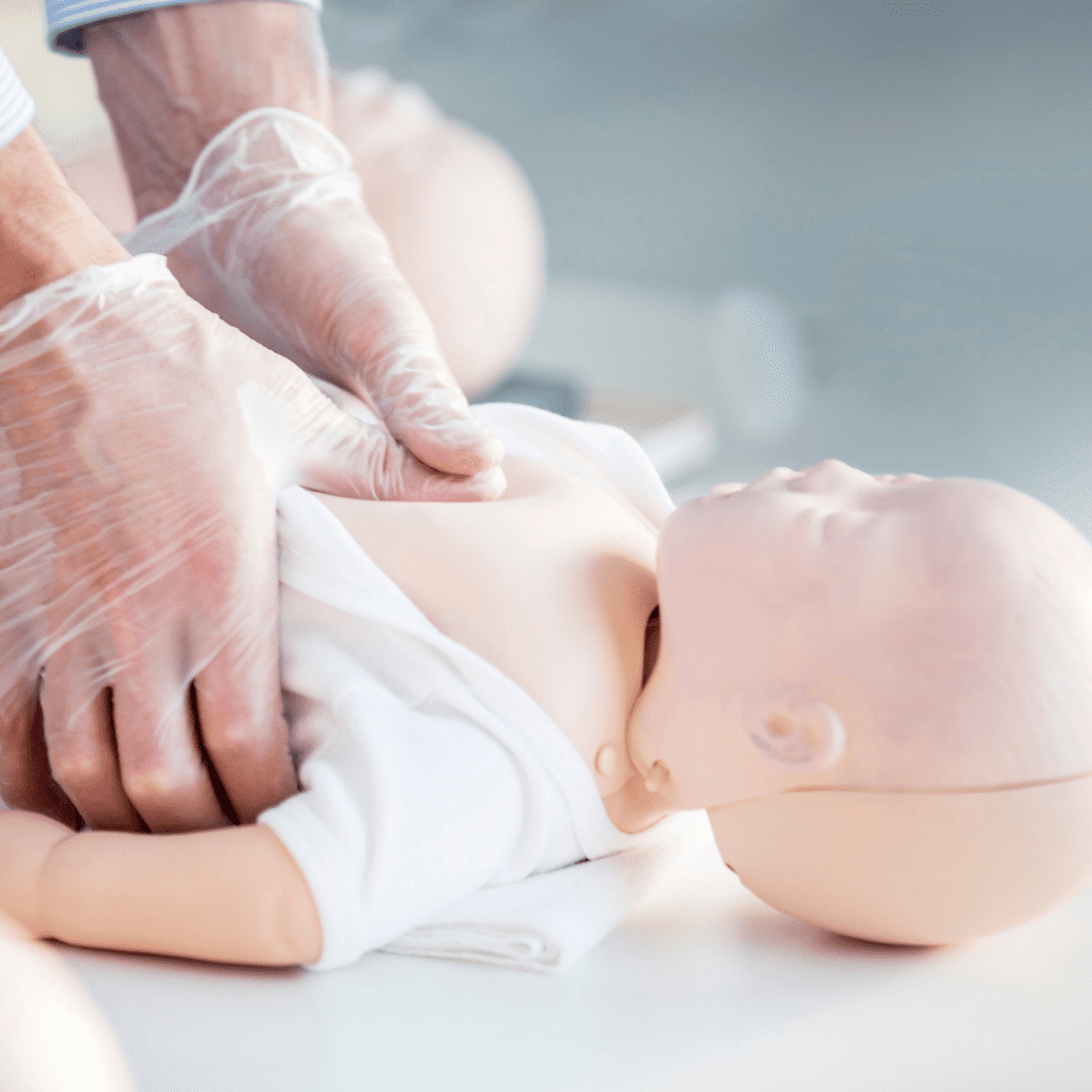 infant cpr course to get ready for introducing solids around 6 months; performing infant cpr on an educational doll