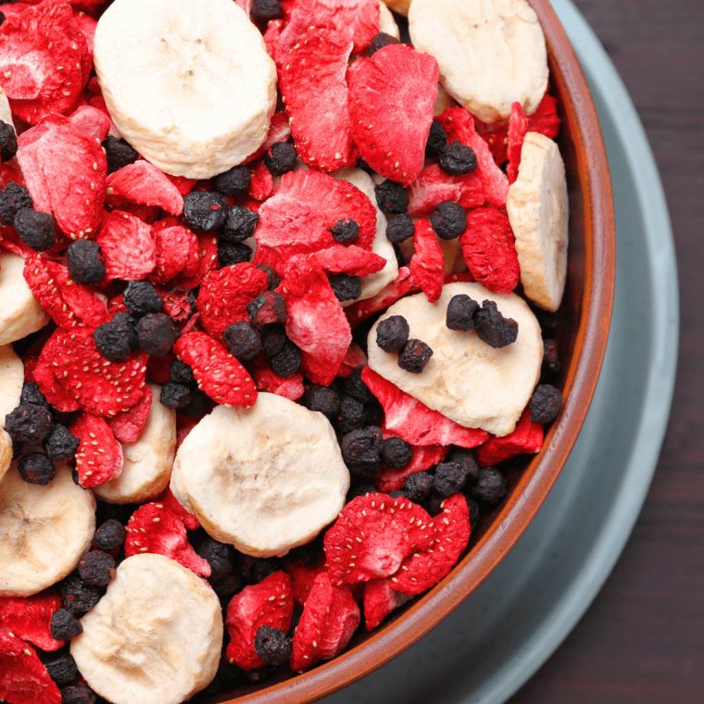 A bright bowl of freeze-dried fruit including strawberries, bananas, and blueberries. 