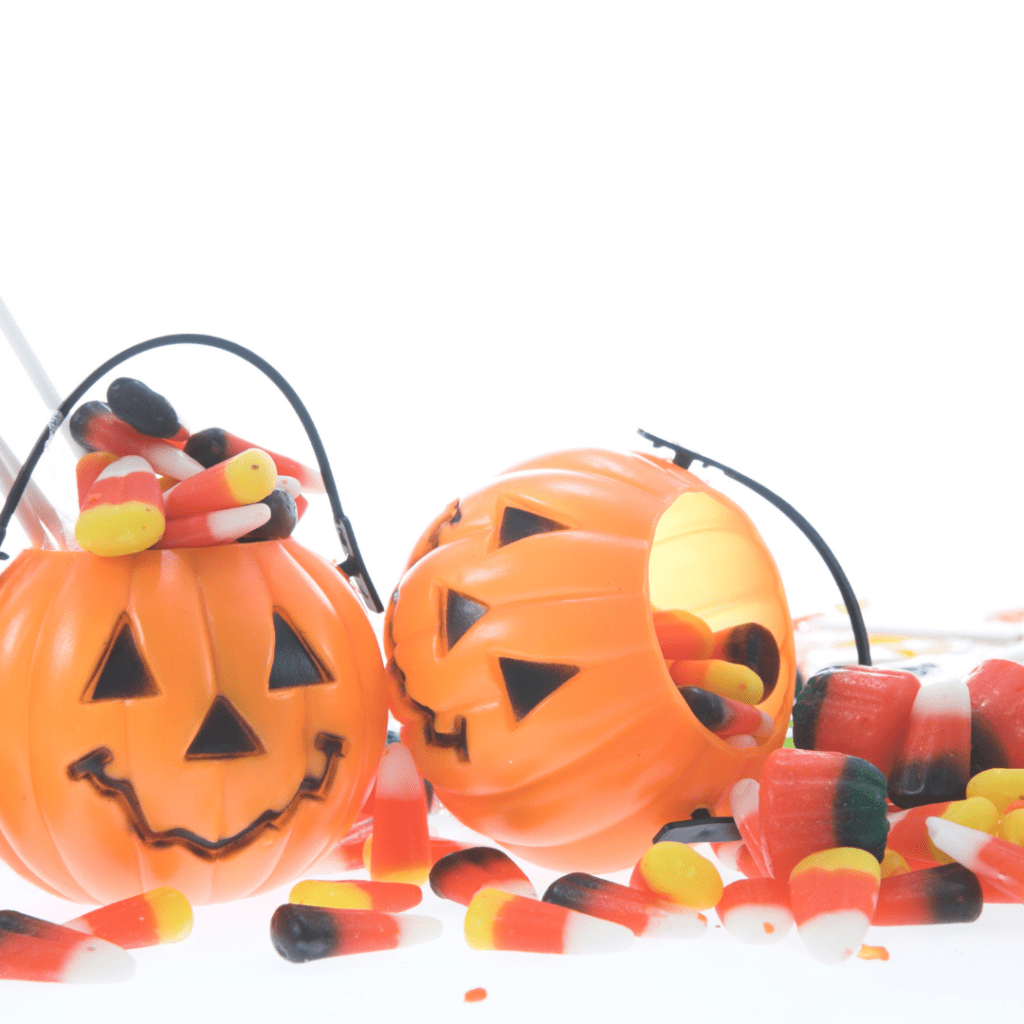 Halloween trick-or-treat jack-o-lantern buckets filled with candy corn and jelly beans for toddlers.