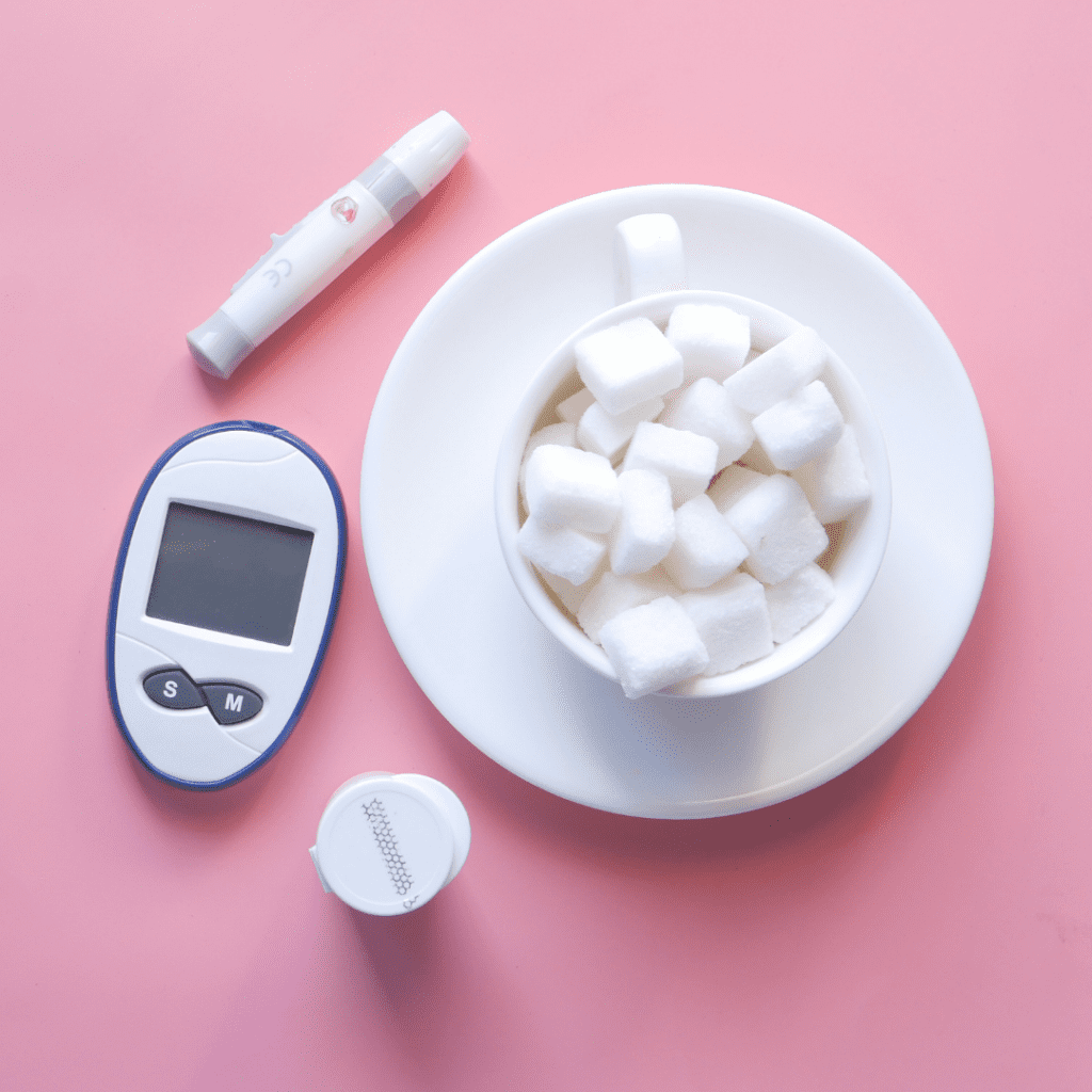 Glucose monitor and a bowl of sugar cubes demonstrating diabetes.