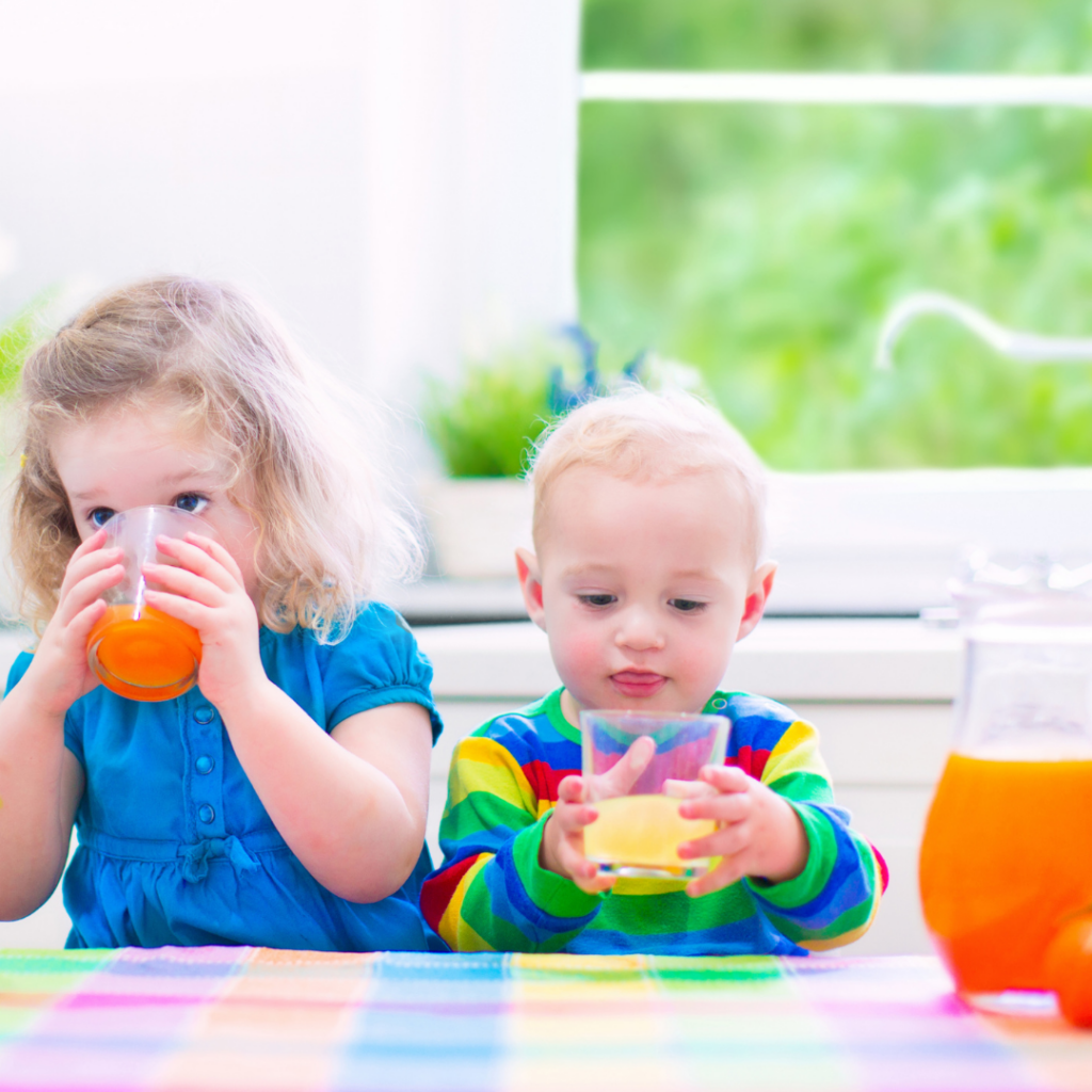 Young child and toddlers drinking juice.