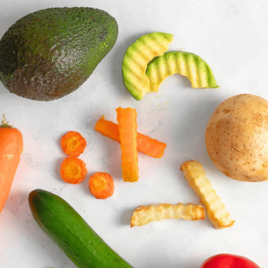 Fruits and vegetables cut using a crickle cutter for baby led weaning, including avocado, carrots, and potatoes.