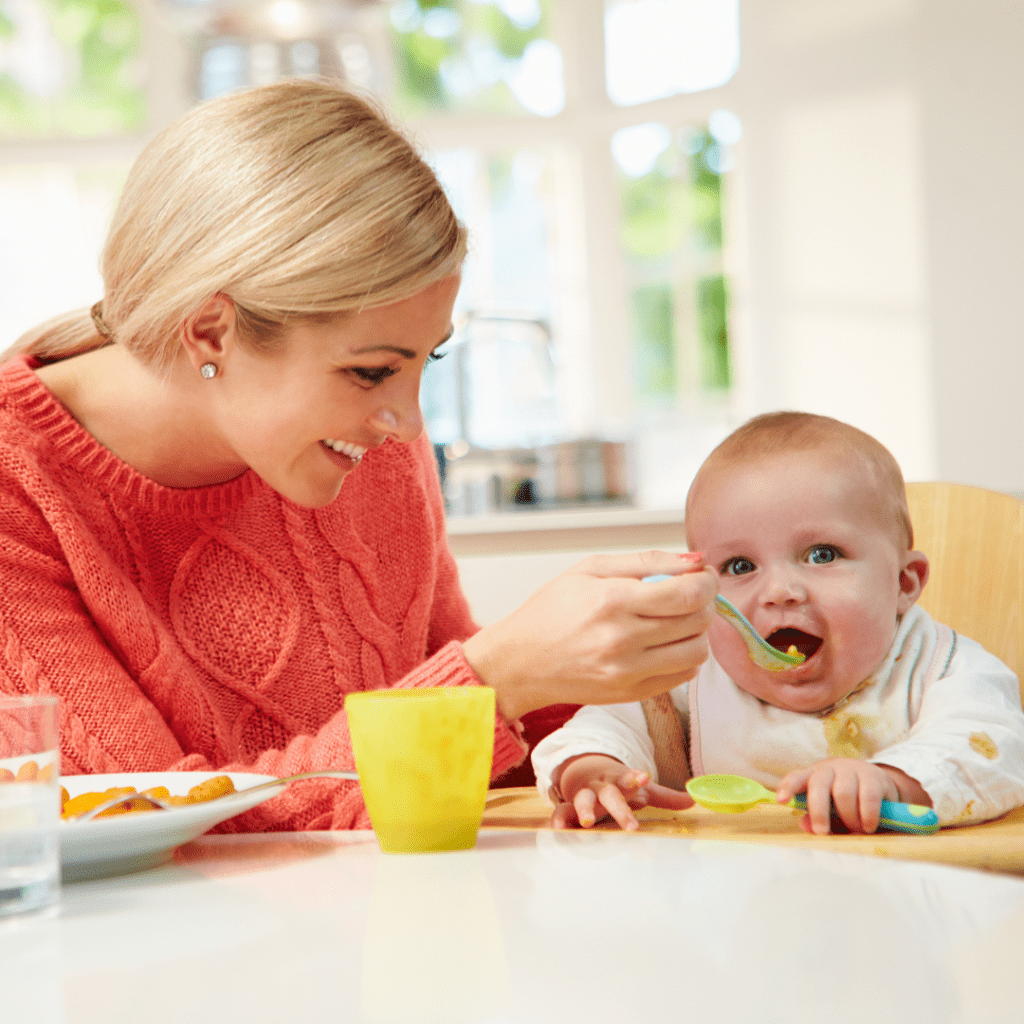 Include family meals in your routine for baby to learn to pick up food by watching you. Baby eats sweet potato with mom.