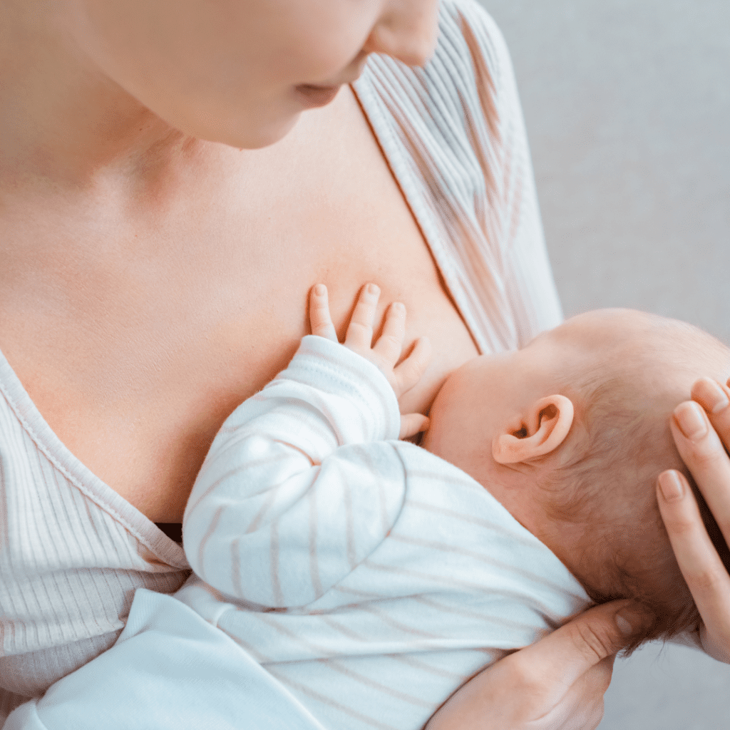A newborn infant breastfeeds.