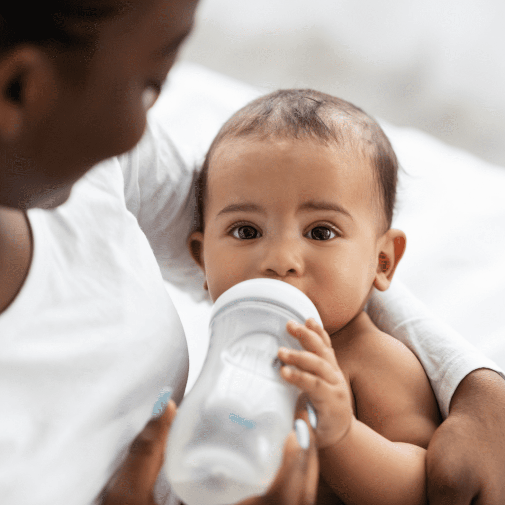 Baby drinks from a bottle.
