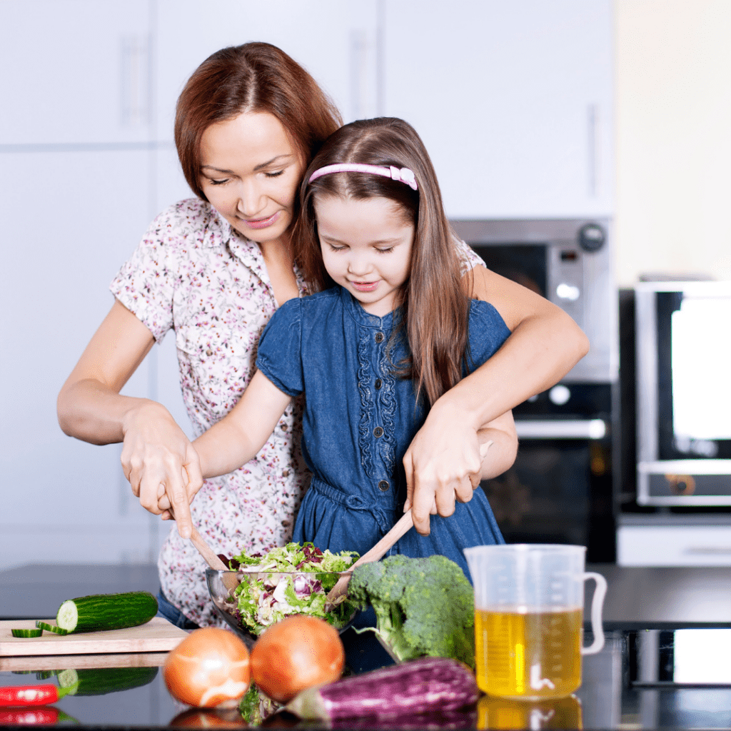 Older children can get involved with cooking too, here a child helps mix a salad with their parent.