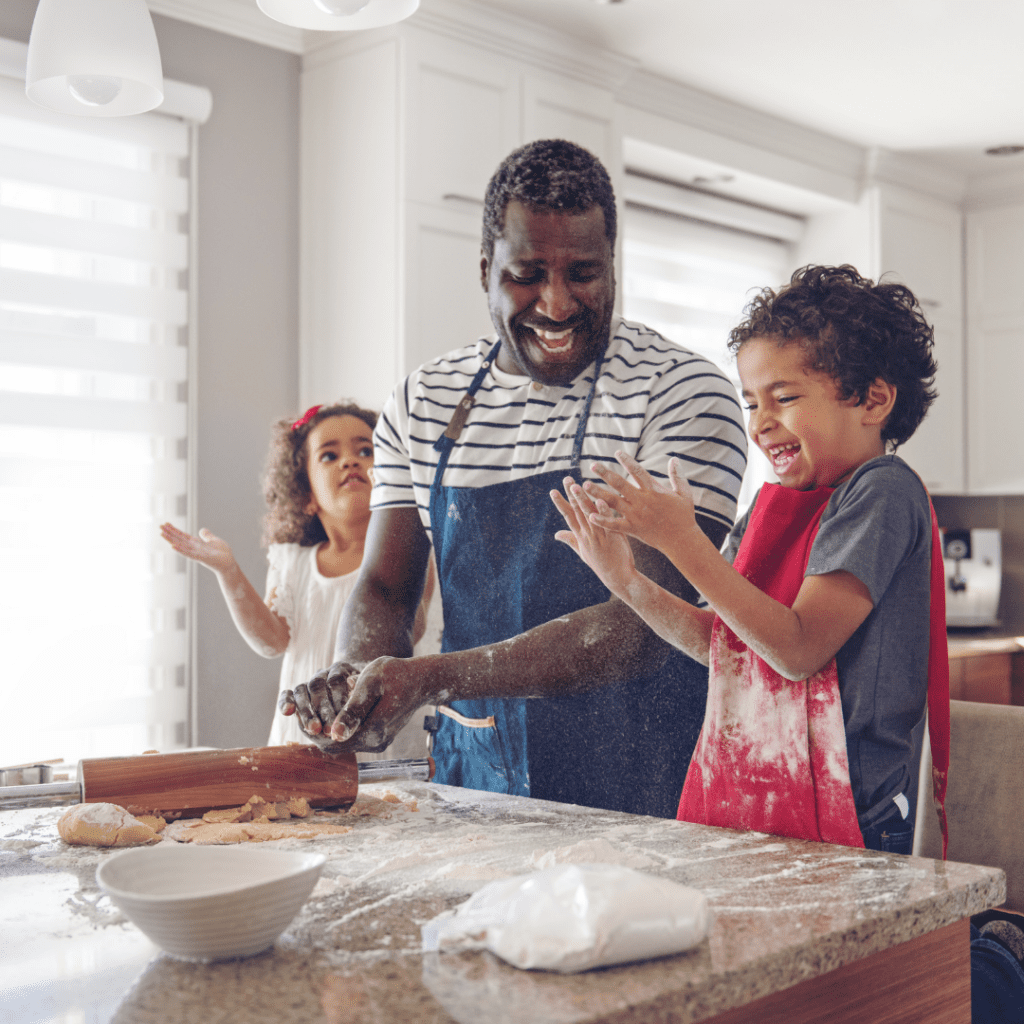 A positive cooking experience with a dad and his two kids, laughing while they get messy making pizza dough.