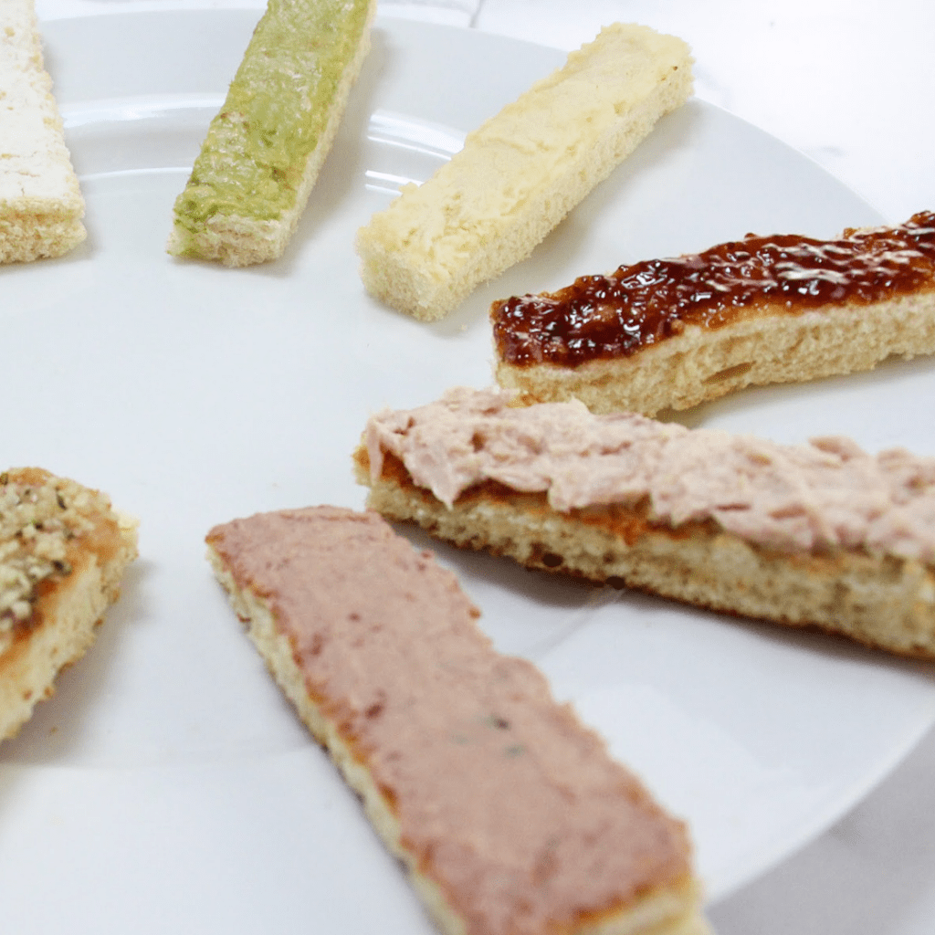 7 strips of toasted plated together, all with various toast toppings and some toppings contain top allergens for babies.