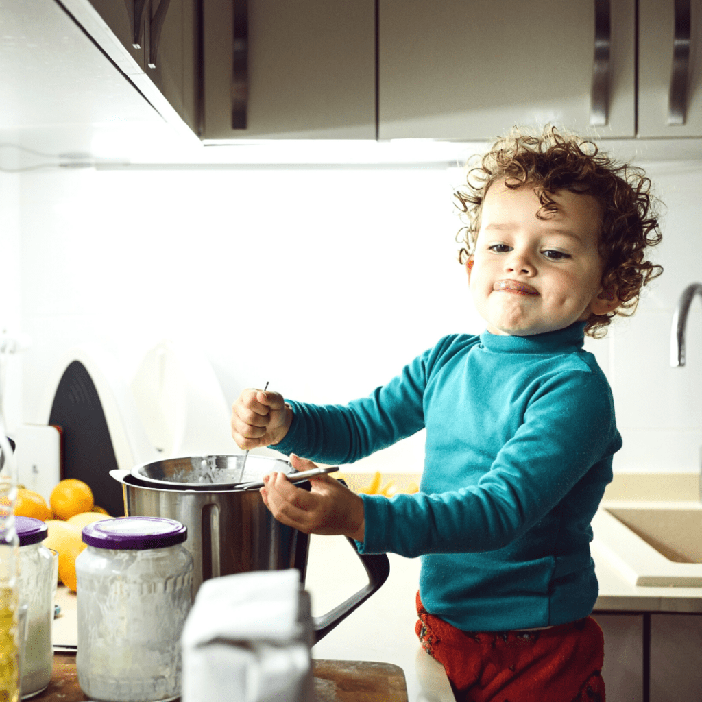 Toddler recipes can be simple enough for them to help with, here a toddler helps stir a pot, and can introduce them to new foods.