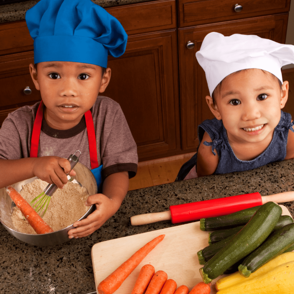 Two toddlers help cook as a method for preventing picky eating behaviors.