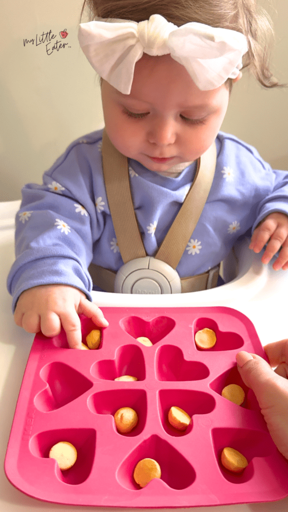 Baby begins to use the inferior pincer grasp to pick up small, soft finger foods like Amara Organic Smoothie Melts.