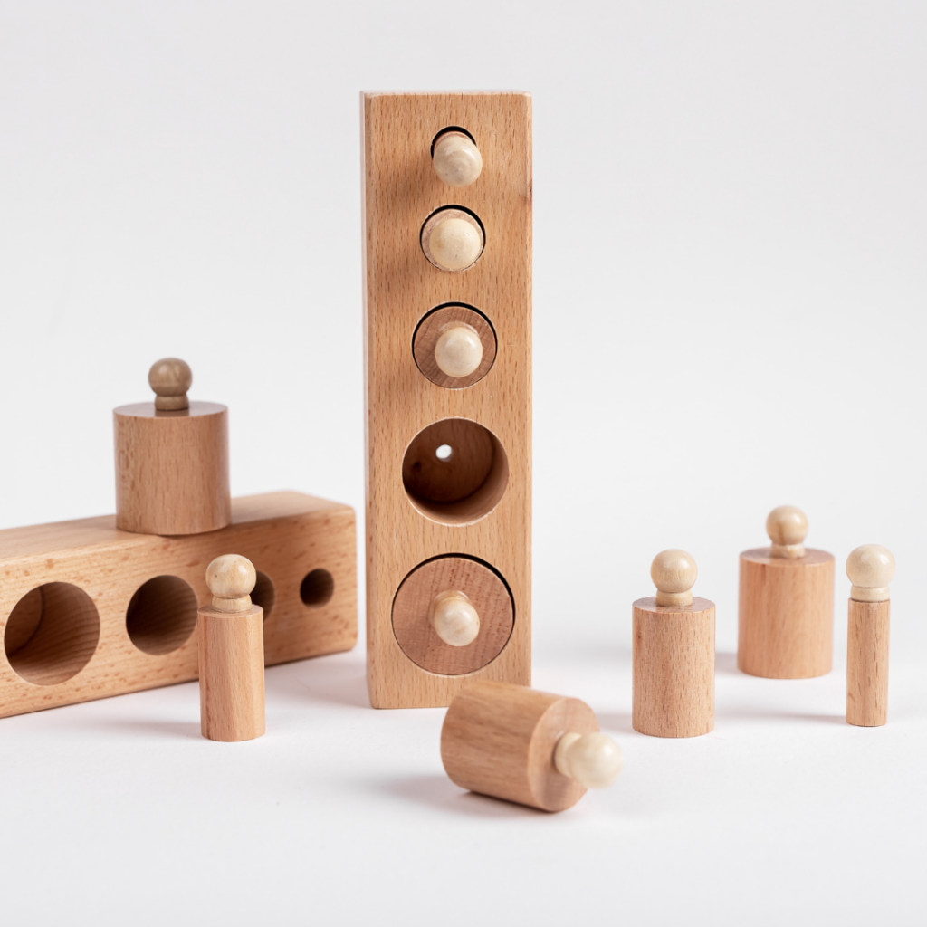 Montessori knobbed wooden cylinder puzzle for babies to use in pincer grasp activities to practice their ability to grasp small objects.