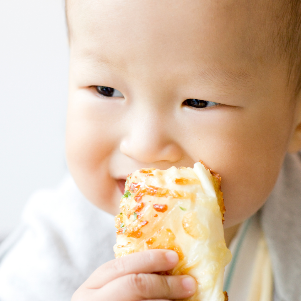 Baby eating a cheese breadstick.