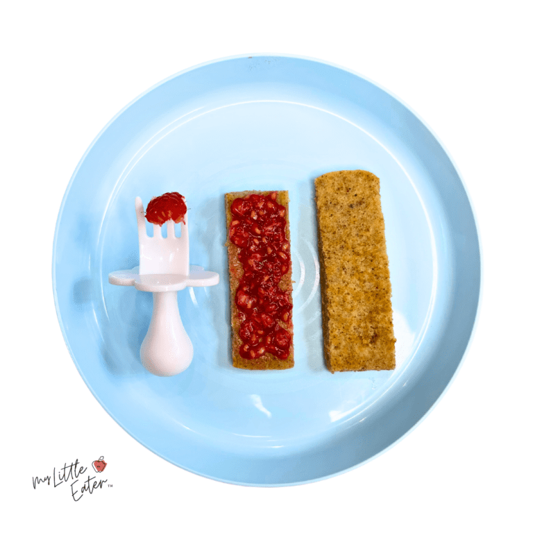 Banana almond pancake fingers served with raspberries spread on top and on the side served on a fork.