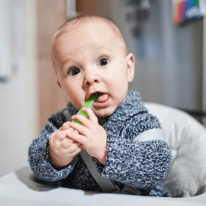 Young baby chewing on a spoon.