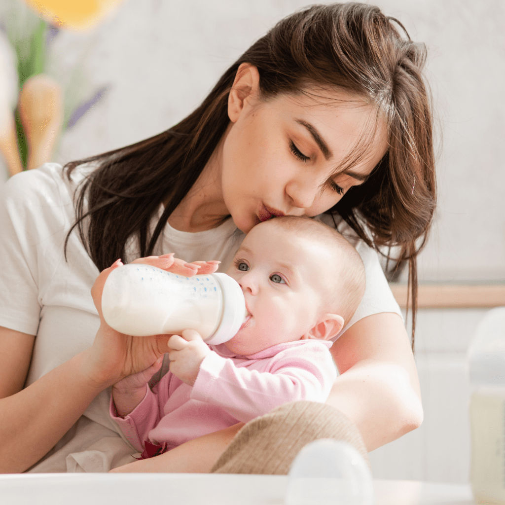 How to pick the best formula for your baby; a mom kisses her baby's head while they drink a bottle.