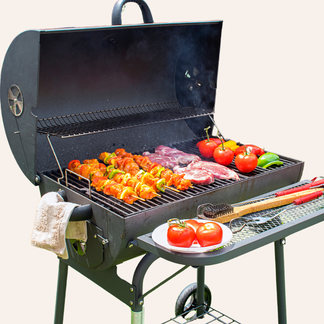 An open barbecue cooking beef, kabobs, tomatoes, and peppers.