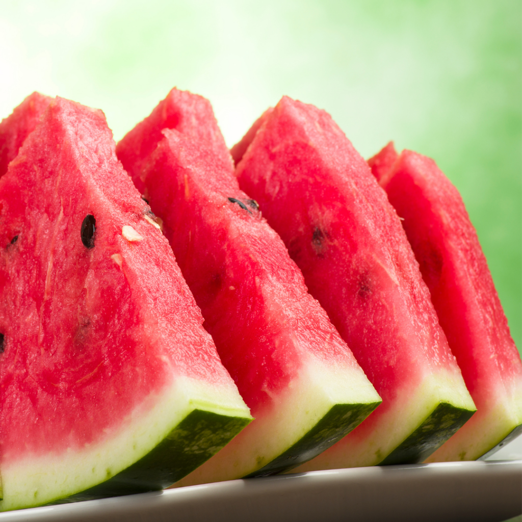 Four vibrant, fresh watermelon slices placed upright vertically.