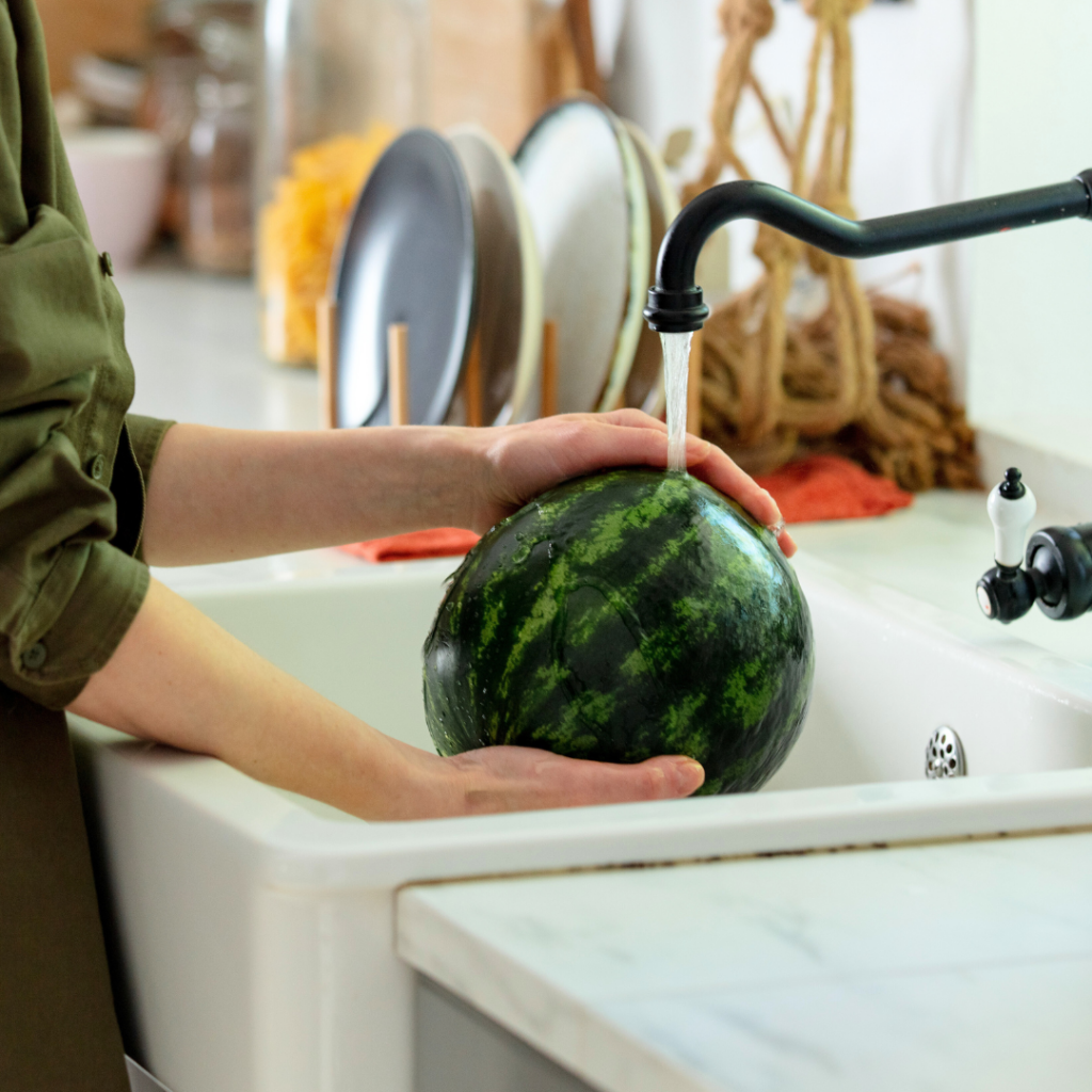 Washing a watermelon under water before letting a baby eat watermelon (for food safety).