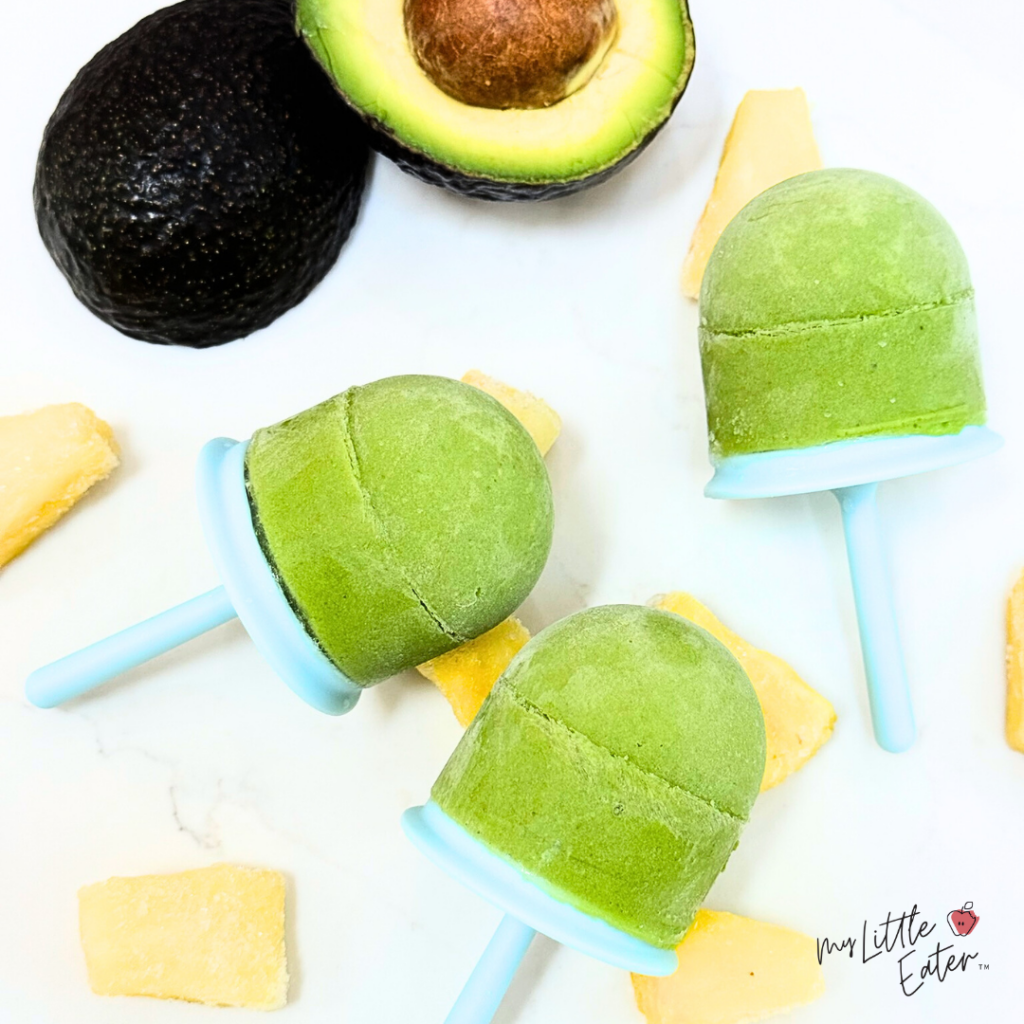 Bright green popsicles with pineapple and avocado.