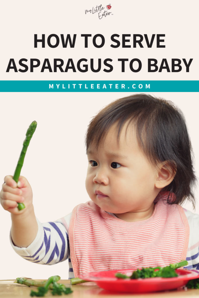 Asparagus for baby - how to serve it safely; baby holds up an asparagus spear.