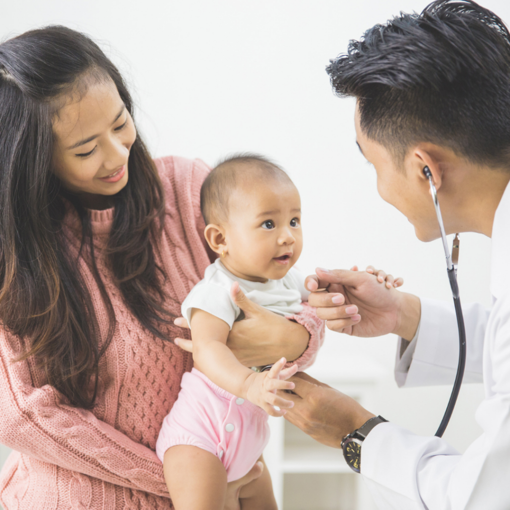 Baby is being held by mother while a doctor examines them at a checkup monitoring weight gain.