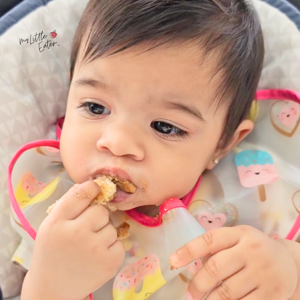 Babies eat bread safely as toast, like this baby eating toast topped with nut butter.