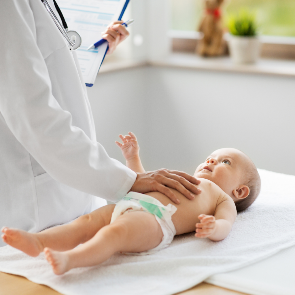 Infant growth is assessed at a doctor's office with a baby in a diaper being examined.