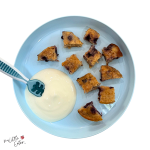 Pancake pieces made from pancake freezer pucks on a baby plate with yogurt.