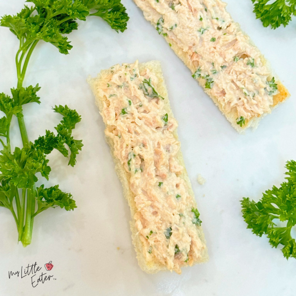 Toast with salmon, mayonnaise and parsley.