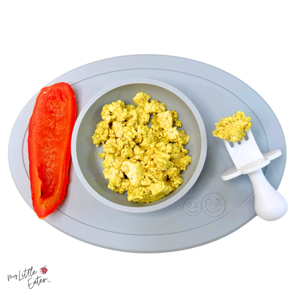 Curried tofu scramble with steamed bell pepper on the side for baby led weaning.