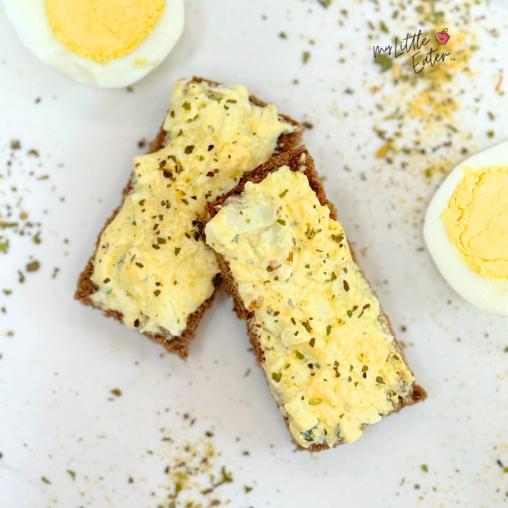 Toast with a thin layer of mashed boiled eggs and Greek yogurt with herbs and spices.