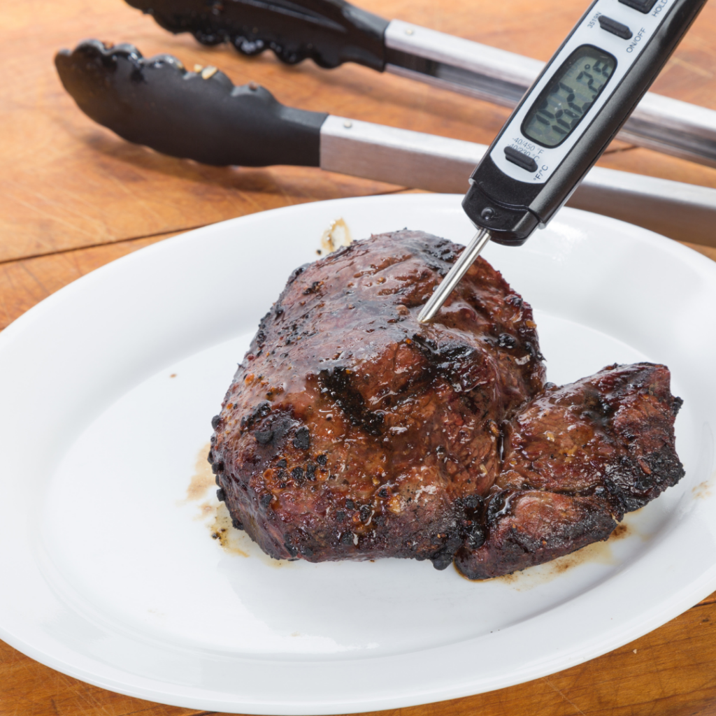 Properly cooked meat that is being checked by a meat thermometer.