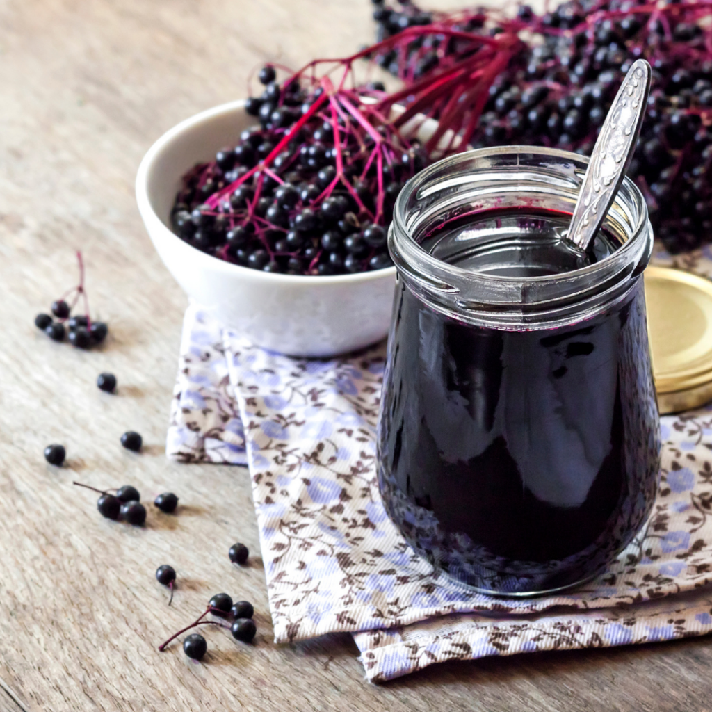 Elderberries in a bowl and elderberry syrup in a jar to help with cold symptoms, sometimes kids experience up to six to eight colds in a year.