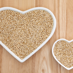 Uncooked quinoa seeds in two bowls shaped like hearts.