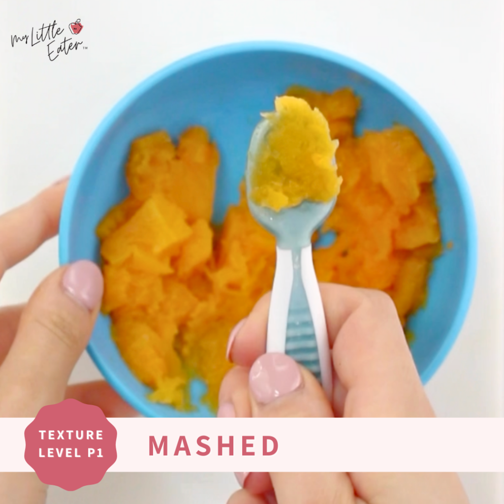 Mashed butternut squash in a bowl with some preloaded on a prespoon for baby.